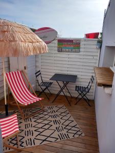 un patio con mesa, sillas y sombrilla en Côte d'Opale - Maison Cocooning Classé 3 Étoiles en Marquise