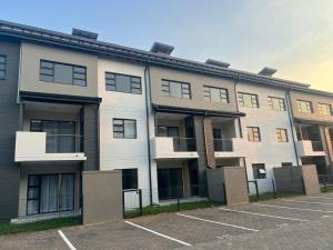 an empty parking lot in front of an apartment building at Fun modern two bed apartment in fourways in Sandton