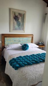 a bed with a blue tufted blanket on it at Apto Duplex com Mezanino in Juquei