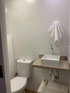 a white bathroom with a toilet and a sink at estúdio reformado em copacabana in Rio de Janeiro