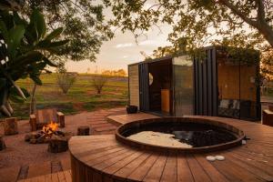 a hot tub on a wooden deck with a fire pit at Esphera Glamping - Gravataí - RS in Gravataí