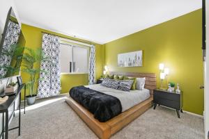 a bedroom with a large bed with green walls at Beverly Hills Gem 1 BR Apt with Parking 218 in Los Angeles