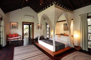 um quarto com uma cama de dossel num quarto em Villa Bali Asri em Seminyak