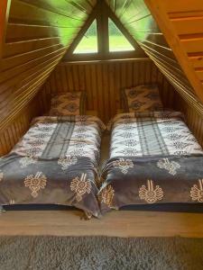 a couple of beds in a room with a window at Domki u Marii- agroturystyka in Bańska Niżna