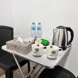 a table with two coffee cups and a tea kettle at Desert Moon in Wadi Musa