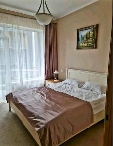 a bedroom with a large bed and a large window at Turaidas apartment Jurmala in Jūrmala