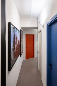 un couloir avec une porte rouge et des peintures murales dans l'établissement Maison Ammiragli Vatican Rooms, à Rome