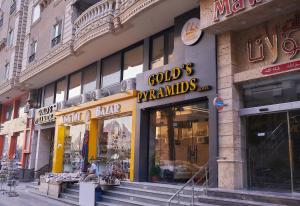 una tienda frente a un edificio con letreros. en Gold's Pyramids Hotel, en El Cairo