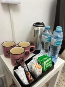 a shelf with two bottles of water and some cups at Desert Moon in Wadi Musa