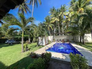 a swimming pool in a yard with palm trees at Casa De Playa El Encanto in El Porvenir