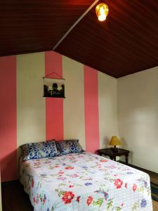 1 dormitorio con 1 cama con rayas rojas y blancas en Casa Enverdes, en Guasca