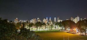 un parque con un perfil urbano por la noche en Terraza del Plaza en Rosario