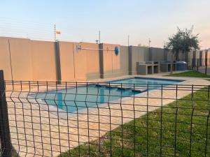 a swimming pool with a fence around it at Fun modern two bed apartment in fourways in Sandton