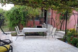 un patio con una mesa y sillas blancas y un edificio en yeşillikler içinde bağ evi, 