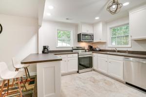 a white kitchen with white cabinets and a counter at Charming Apartment in Downtown Georgetown! in Georgetown