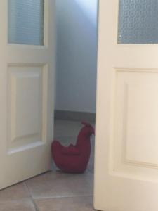 un poulet en caoutchouc rouge assis à côté d'une porte dans l'établissement Casa Rosaria, à Monopoli