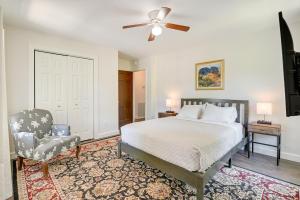 a bedroom with a bed and a chair and a ceiling fan at Charming Apartment in Downtown Georgetown! in Georgetown