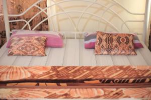 a bed with two pillows on top of it at Emmas' Guest House in Kampala +48 photos