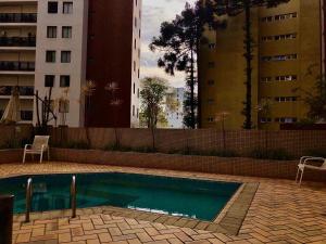 a swimming pool in a building with two tall buildings at Apartamento aconchegante no Batel in Curitiba