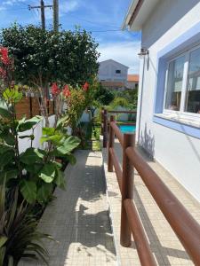 een loopbrug buiten een huis met planten bij Vila Vale Guest House - Surf & Yoga in Charneca