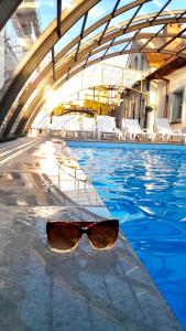 um par de óculos de sol sentado à beira de uma piscina em Wczasowa 8 Apartments em Sarbinowo