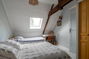 - une chambre avec 2 lits et une fenêtre dans l'établissement LES DEUX RIVIERES - Chambres & Table d'Hôtes -, au Faouët