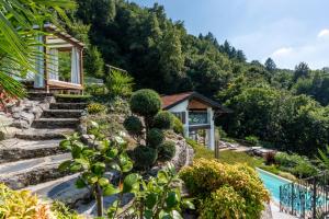 a garden with a house and a swimming pool at Villa Rosch in Lezzeno