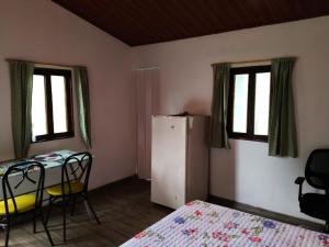 1 dormitorio con mesa, sillas y nevera en Casa Enverdes, en Guasca