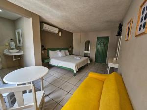 ポサ・リカ・デ・イダルゴにあるHotel Punto Poza Ricaのベッドルーム1室(ベッド1台、テーブル、テーブル付)