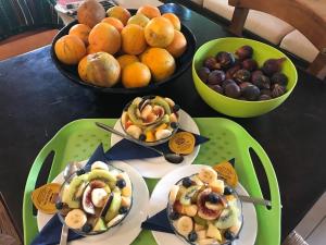 una mesa con platos de comida y cuencos de fruta en Pension Aretoussa, en Pitsidia