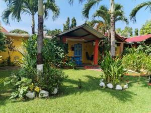 una casa amarilla con palmeras delante en Las Catalinas Coronado, en Playa Coronado