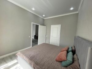 een slaapkamer met een bed met kussens erop bij Sat City Deluxe in Astana
