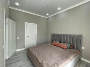 een slaapkamer met een bed met een oranje kussen erop bij Sat City Deluxe in Astana