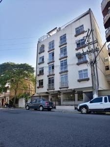 dos coches estacionados frente a un edificio en 100m PRAIA DO FORTE Cabo Frio ,1 quarto, ar condicionado,cozinha ,garagem a 5 minutos de restaurantes e comercio, en Cabo Frío