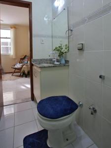 baño con aseo y asiento azul en 100m PRAIA DO FORTE Cabo Frio ,1 quarto, ar condicionado,cozinha ,garagem a 5 minutos de restaurantes e comercio, en Cabo Frío