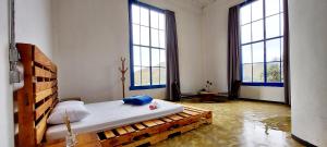 um quarto com uma cama grande e 2 janelas em Suíte Senhor de Engenho em Nova Lima