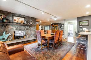 a dining room with a table and a stone wall at Scorpio Condominiums by Vail Realty in Vail