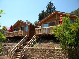 una cabaña de madera con escaleras que conducen a ella en Azra Villas, en Cıralı