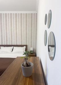 a bedroom with a bed and a table with a potted plant at Guest House on Meskheti in Borjomi