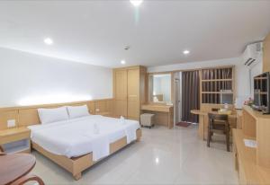 1 dormitorio con 1 cama blanca grande y escritorio en Siam Privi Hotel, en Bangkok