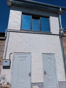 a white building with two doors and two windows at Tevosyan EVN Airport in Pʼarakʼar