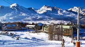 une station de ski avec des montagnes enneigées en arrière-plan dans l'établissement Coquet studio à Le Dévoluy de 24 m², à Saint-Étienne-en-Dévoluy