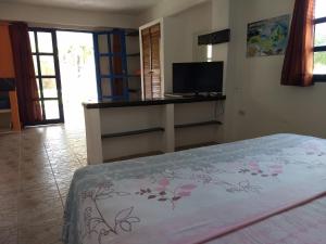 a bedroom with a bed and a flat screen tv at Villa Cocuyo Studios in El Cardón