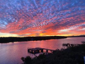 un tramonto su un lago con un molo in acqua di Oppikrom Rivertide 36 a St Francis Bay