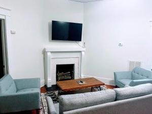 uma sala de estar com dois sofás e uma lareira em Walk To Duke Campus! 3 Bedroom In Trinity Park! em Durham