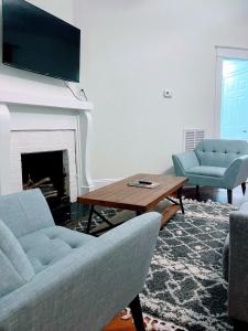 uma sala de estar com um sofá, uma mesa e uma lareira em Walk To Duke Campus! 3 Bedroom In Trinity Park! em Durham