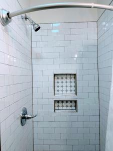 um chuveiro com uma janela numa casa de banho em azulejos brancos em Walk To Duke Campus! 3 Bedroom In Trinity Park! em Durham
