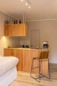 ein Schlafzimmer mit einem Bett und einem Stuhl sowie eine Küche in der Unterkunft Azcuenaga 2862 by depptö in Martínez