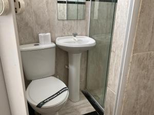 a bathroom with a toilet and a sink and a shower at Pousada Pitanga in Maceió