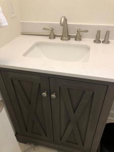 a bathroom sink with a white counter top at Lakewoodlyon Park Renovated Cottage Near Duke 23a in Durham +4 photos